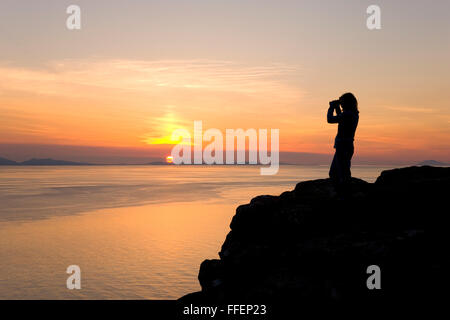 Glendale, Isle Of Skye Highland, Schottland. Junge Frau Tierwelt Schmierblutungen von Klippen landschaftlich Zeitpunkt Sonnenuntergang. Stockfoto
