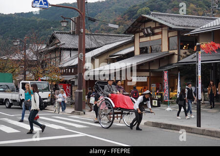 Menschen genießen eine Rikscha fahren in der touristischen Zone von Arashiyama, Kyoto, Japan Stockfoto