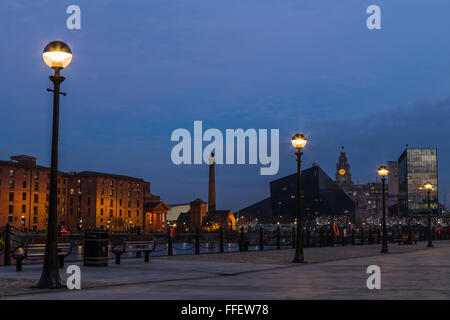 Bright Straßenbeleuchtung entlang der Seite des Salthouse Dock in Liverpool vor der legendären Albert Dock am Wasser gesehen. Stockfoto