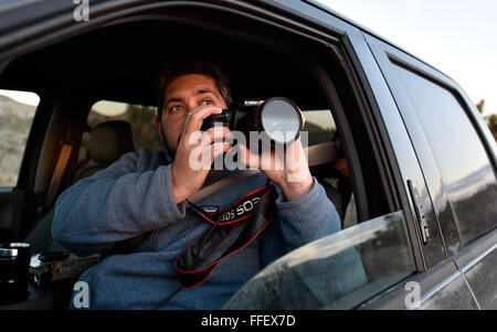 Suchscheinwerfer, Nevada, USA. 12. Februar 2016. Regisseur David Lamfrom der kalifornische Wüste und National Wildlife wird ein Foto vom seine LKW-Fenster gefangen, da er hohe Wüstengebiet der Burg Berge Montag, 1. Februar 2016 Touren. Eine 21.000 Hektar großen Parzelle südwestlich von Searchlight, Nevada in Kalifornien wird vorgeschlagen, als nationales Denkmal zum Schutz einer Fläche weggelassen, wenn die 1,5 Millionen Hektar großen Mojave National Preserve 1994 gegründet wurde. US-Präsident Barack Obama nutzt seine Autorität unter dem Antiquities Act erstelle ich drei Denkmäler der Mojave-Wüste auf fast 2 Millionen Hektar einschließlich der rund Stockfoto