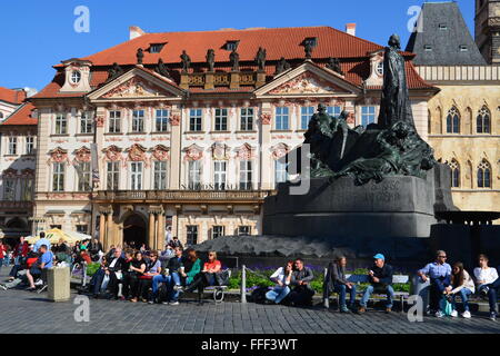 Touristen sitzen vor dem Jan-Hus-Denkmal am Altstädter Ring in Prag, Tschechien. Stockfoto