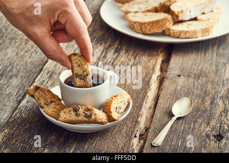 Hand-Dip Cantucci in den Kaffee. Typische italienische cookies Stockfoto