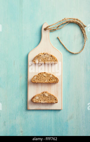 Cantucci auf weiß Hacken von Board und blauen Holztisch. Typische italienische cookies Stockfoto