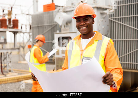 glücklich afroamerikanische Techniker halten Blaupause im Umspannwerk Stockfoto