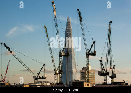 Baukräne im Vordergrund mit The Shard im Hintergrund an sonnigen Tag in London UK. Stockfoto