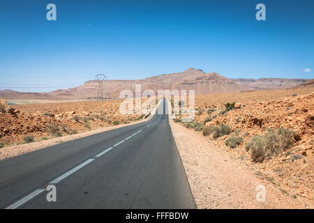 Endlose Straße in der Wüste Sahara mit blauem Himmel, Marokko Afrika Stockfoto