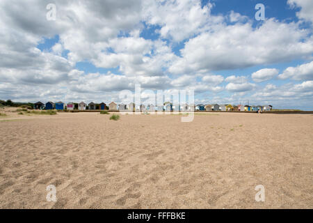 Zeile des traditionellen Englischen Strandhütten mit vielen Wolken und Sand, Nordsee, Sutton-on-Sea, Lincolnshire, England, Großbritannien Stockfoto