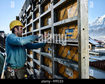 Bauarbeiter mit Hammer, verbindendes Element auf Schalung Wand, Innsbruck Land, Tirol, Österreich Stockfoto