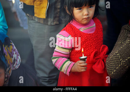 Kathmandu, Nepal. 13. Februar 2016. Ein Kind mit Butterlampe in den Räumlichkeiten der Idol-Göttin Saraswati während einer Vasant Panchami oder Shree Panchami Festival in Kathmandu, Nepal © Narayan Maharjan/Pacific Press/Alamy Live News Stockfoto