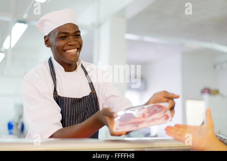 freundliche afrikanische Metzgerei Rindfleisch an Kunden zu verkaufen Stockfoto