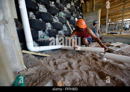 (160213)--MONTEVIDEO, 13. Februar 2016 (Xinhua)--Freiwillige Arbeit in den Bau der ersten selbsttragenden Schule in Lateinamerika, in Jaureguiberry, 80 km von Montevideo, Hauptstadt von Uruguay, am 12. Februar 2016. Laut Lokalpresse wird Michael Reynolds, Schöpfer des Unternehmens "Earthship Biotecture", der Hersteller der ersten öffentlichen Schule von hundert Prozent autark in Lateinamerika, autark in der Erzeugung von Strom, Heizung und Wasser sein. Das innovative Gebäude verfügt über 270 Quadratmeter und kombiniert traditionelle Elemente der Gebäudesysteme als Vermischung mit stillgelegten Stockfoto