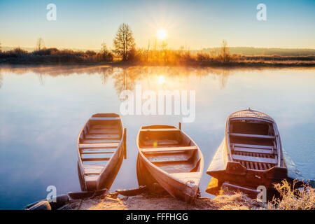 Fluss und Rudern Fischerboot am wunderschönen Sonnenaufgang in Herbstmorgen. Alten Holzboote Stockfoto