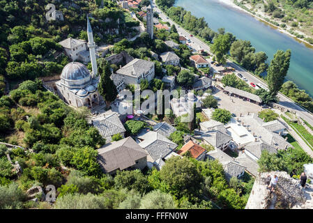 Hajji Alija Moschee und Sahat Kula Glockenturm in Pocitelj Dorf über den Fluss Neretva, Bosnien und Herzegowina. Blick von der Festung Stockfoto