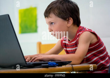 Kind spielt mit laptop Stockfoto