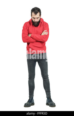 : Bärtiger Mann mit verschränkten Armen in rotes Sweatshirt mit Kapuze blickte. Ganzkörper-Länge-Porträt isoliert auf weißem Hintergrund Stockfoto