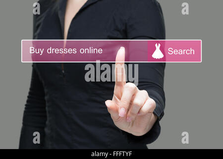 Mädchen klickt auf virtuelle Tastatur - kaufen Online-Kleid Stockfoto