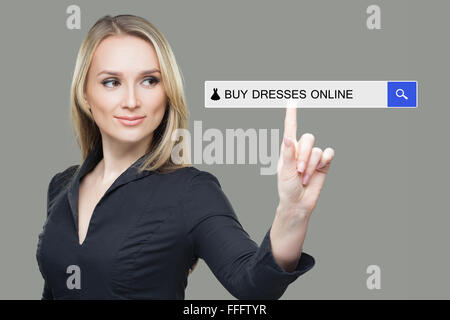 Mädchen klickt auf virtuelle Tastatur - kaufen Online-Kleid Stockfoto
