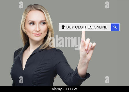 Mädchen klickt auf virtuelle Tastatur - online Kleidung kaufen Stockfoto