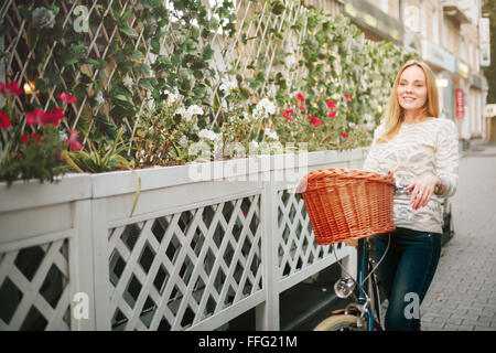 Junge glückliche Frau auf einem Vintage Fahrrad an der Stadtstraße wegsehen und lächelnd. Selektiven Fokus. Stockfoto