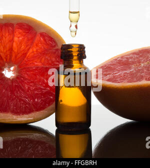 Ätherisches Öl Braunglas-Flasche mit Grapefruit-Scheiben mit Pipette Stockfoto