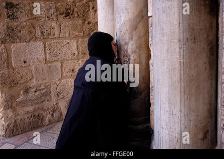 Eine orthodoxe christliche Pilger küssen die Spalten die Kreuzritter Graffiti, meist bestehend aus Kreuze am Eingang zum Heiligen Grab Kirche in Christian Quarter fallen alte Stadt Ost-Jerusalem Israel Stockfoto