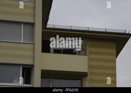 Worms, Deutschland. 13. Februar 2016. Eine Frau zeigt einen Banner auf ihrem Balkon, lesen "Nazis kleinen Schniedel haben". Rund 80 Mitglieder der rechten Partei "Der III. Weg "(der dritte Weg) marschierten durch Würmer im Gedenken an die Todesopfer durch alliierte Bombenangriffe in Dresden am 13.. Februar 1945. Sie schlossen sich Neo-Nazis aus Ungarn. Einige Demonstranten gegen den Faschismus Zähler Stand auf dem Weg. Stockfoto