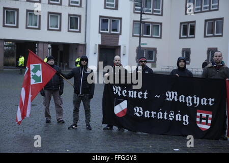 Worms, Deutschland. 13. Februar 2016. Die rechten Demonstranten halten eine kleine Kundgebung auf dem Markt-Platz von Worms. Sie halten eine Flagge des ehemaligen faschistischen Pfeil Cross ungarische Regierung und eine Fahne, die die Freundschaft aus der ungarischen Stadt Remet zeigt. Rund 80 Mitglieder der rechten Partei "Der III. Weg "(der dritte Weg) marschierten durch Würmer im Gedenken an die Todesopfer durch alliierte Bombenangriffe in Dresden am 13.. Februar 1945. Sie schlossen sich Neo-Nazis aus Ungarn. Einige Demonstranten gegen den Faschismus Zähler Stand auf dem Weg. Stockfoto