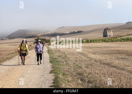 Villafranca Montes de Oca, Spanien: Pilger zu Fuß in der Nähe der Ruins des Klosters von San Félix de Oca auf dem Camino Francés. Stockfoto