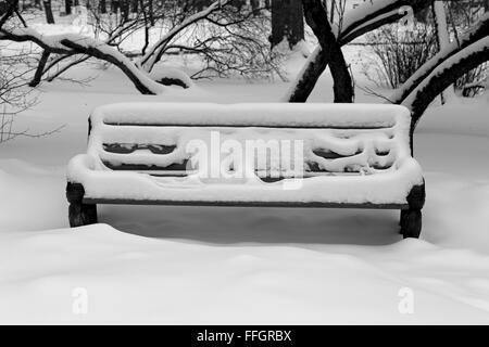 Parkbank bedeckt mit Schnee Stockfoto