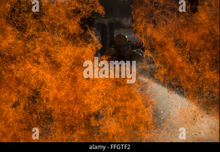 Drei militärischen Schüler zugewiesen, 312th Training Squadron Schlacht ein Feuer während ein flüssiges Feuer-Szenario an der Louis F. Garland Department of Defense Fire Academy, 19. Oktober 2015. Während des Trainings flüssiges Feuer drehen die Studenten durch 3-Mann-Iterationen der niedrigen und hohen Feuer während der Bewegung durch das Wasser. Die gemeinsame DOD-Schule besteht aus Luftwaffe, Heer, Marine, Marine und Zivildienst Studenten. Stockfoto