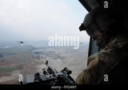 Senior Master Sgt. Todd Peplow, eine Antenne Schütze mit der 438th Air Expeditionary Advisory Squadron, bietet Support für Gunner auf einer afghanischen Luftwaffe MI-17 während eines Fluges über Afghanistan. Peplow ist derzeit eingesetzt, um AAF Flugingenieure am internationalen Flughafen von Kabul beratenden auszubilden. Stockfoto