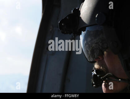 Senior Master Sgt. Todd Peplow, eine Antenne Schütze mit der 438th Air Expeditionary Advisory Squadron, bietet Support für Gunner auf einer afghanischen Luftwaffe MI-17 während eines Fluges über Afghanistan. Peplow ist derzeit eingesetzt, um AAF Flugingenieure am internationalen Flughafen von Kabul beratenden auszubilden. Stockfoto