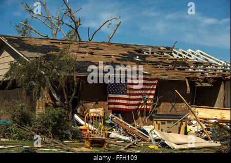 Wohnhaft in Moore, Oklahoma zeigt eine amerikanische Flagge auf ihre Heimat 22. Mai 2013. Am Montag reiste ein EF-5 Tornado mit Winde erreichen mindestens 200 km/h, 20 Meilen, so dass eine zwei-Meile-breite Schneise der Verwüstung, Nivellierung Häuser, Zerkleinern Fahrzeuge und mehr als 20 Menschen getötet. Mehr als 115 Oklahoma Nationalgarde wurde aktiviert, um bei den Rettungs- und Hilfskräfte Bemühungen zu unterstützen. Stockfoto