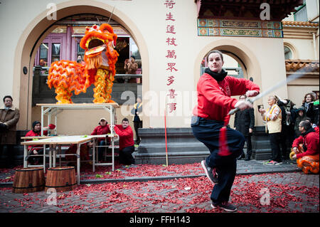 Amsterdam, Niederlande. 13. Februar 2016. Lion Tänzer zu besuchen, die Häuser und Geschäfte von der chinesischen Gemeinschaft den traditionellen Brauch der auszuführenden "cai Qing", eine Quest von dem "Löwen", das verheißungsvolle grün "Gemüse" wie Salat und verheißungsvolle Früchte wie Orangen pflücken gebunden an einen "roten Umschlag" mit Geld. Der Löwentanz wird geglaubt, um Glück und Wohlstand für das Unternehmen zu bringen. Die Truppe ist mit dem roten Umschlag belohnt. Bildnachweis: Romy Arroyo Fernandez/Alamy Live-Nachrichten. Stockfoto