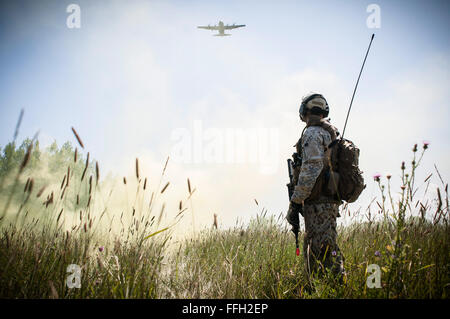 Capt Armands Rutkis kennzeichnet eine Drop-Zone mit Rauch erlauben einen c-130 Hercules, simulierten Fracht fallen während der Operation Northern Strike 2014 in der Nähe von Rogers City, Michigan Der c-130 basiert mit 182. Airlift Wing in Peoria, Illinois Rutkis ist eine gemeinsame taktische Luft-Controller von der lettischen Streitkräfte. Operation Northern Strike 2014 ist eine gemeinsame multinationale kombinierte Waffen training Übung in Michigan durchgeführt. Stockfoto