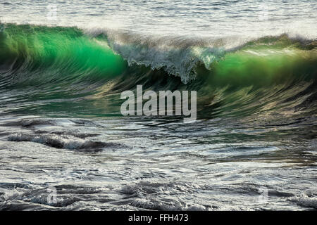 Leuchtende Abendlicht durchscheint einlaufenden Wellen am Hapuna Beach auf der Big Island von Hawaii. Stockfoto