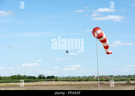 Windsack und werde das Flugzeug auf einem Hintergrund des blauen Himmels zu landen. Stockfoto