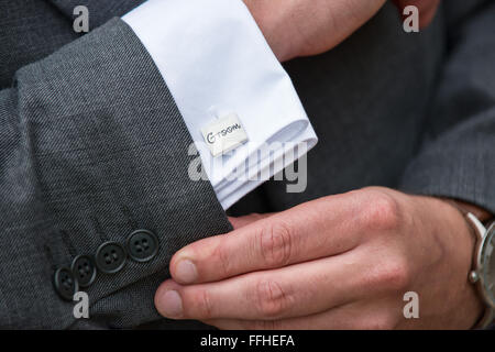 Ein Bräutigam Hände seine Ärmel bei seiner Hochzeit, offenbart seine Hemden Manschette & Silber Manschettenknöpfe Anzeige den Wort Bräutigam anpassen Stockfoto