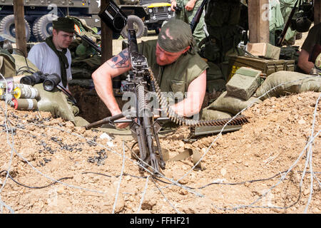 Vietnam Krieg Re-enactment. Von außen uns Holz überdachte Command Bunker am Checkpoint, Marine in Flake Jacket Prüfung M60 Maschinengewehr Stockfoto