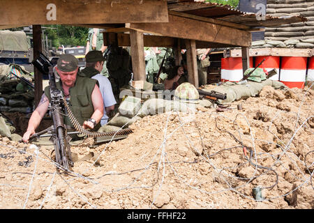 Vietnam Krieg Re-enactment. Von außen uns Holz überdachte Command Bunker am Checkpoint, Marine in Flake Jacket Prüfung M60 Maschinengewehr Stockfoto