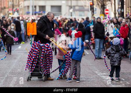 Manchester Chinese New Year feiert heute (Sonntag, 7. Februar 2016). Ein Mann verkauft Dekorationen für Kinder Stockfoto