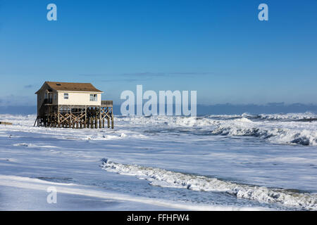 Strandhaus auf Stelzen, umgeben von hohen Gezeiten Surf, Nags Head, Outer Banks, North Carolina, USA Stockfoto