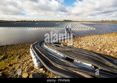 Die neue schwimmende solare Farm als Raster verbunden Godley Reservoir in Hyde, Manchester, UK. Das Schema ist ein 3-MW-System, bestehend aus 10.000 Photovoltaik-Paneele. Es wird United Utilities Stromrechnung auf der Kläranlage vor Ort, rund 7.000 £ pro Monat einsparen. Es ist die größte schwimmende solar Farm in Europa und der zweitgrößte in der Welt. Es liefert rund 33 % der Wasseraufbereitung Energiebedarf Pflanzen. Stockfoto