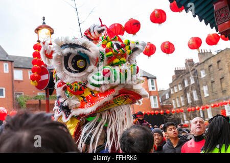 London, UK. 14. Februar 2016. Eine traditionelle Löwe-Tänzerin mit Maske geht durch China Town. Für das Ritual Choi Ching ist Kohl, als Symbol für Glück, hängt von den Eingängen der Geschäfte und Restaurants in den Straßen von China Town, oder auf einem Hocker angeboten und dann packte ein Löwe-Tänzer.  Beigefügt sind rote Umschläge als Opfergabe an den Löwen.  Londoner Feierlichkeiten sollen die größten außerhalb Chinas sein. Bildnachweis: Imageplotter und Sport/Alamy Live Nachrichten Stockfoto