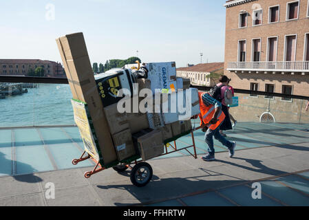 Ein Portier, der einen beladenen Trolley oder Wagen über die Ponte della Costituzione schiebt, ist die vierte Brücke über den Canale Grande in Venic Stockfoto