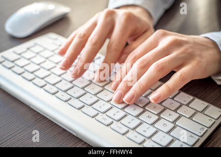 Weibliche Hände auf der Tastatur tippen. Stockfoto