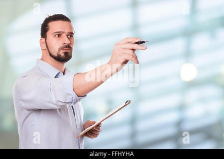 Geschäftsmann schreiben auf einem Klemmbrett. Stock Bild Stockfoto