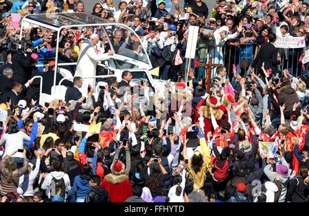 Mexico City, Mexiko. 13. Februar 2016. Papst Francis wird von Tausenden von Anhänger aus seinem Papamobil auf dem Weg zur Messe in der Basilika der Jungfrau von Guadalupe in Mexiko-Stadt, Mexiko 13. Februar 2016 feiern begrüßt. Stockfoto