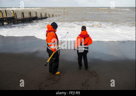 Zwei Umweltwissenschaftler Probenahme Wasser Qualität im Meer vor dem Strand von Aberystwyth an der Westküste von Wales. Flusswasser wurdest, mit Bakteriophagen und deren Verteilung und Verdünnung im Meer wird alle 60 Minuten für 48 Stunden gemessen wird Stockfoto