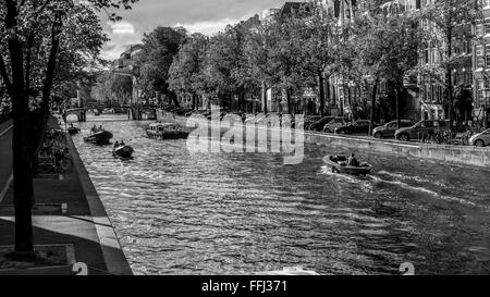 Amsterdam Szene Wasserkanal und Boote in Amsterdam. Schwarzweißansicht auf touristische und Boote am Nieuwe Herengracht Kanal. Stockfoto